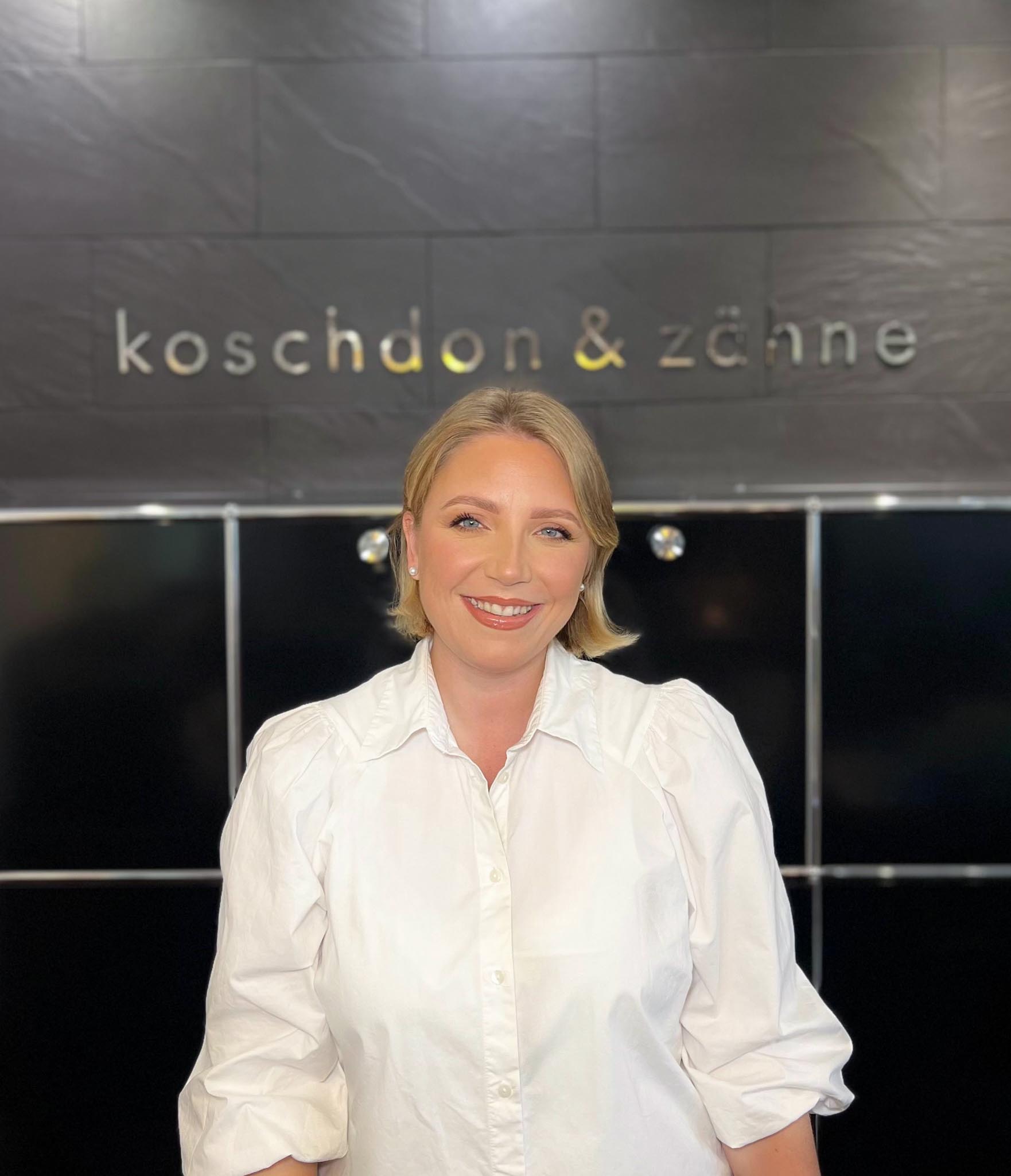 Zahnarzt Neu-Isenburg koschdon & zähne: Mitarbeiterin mit weißer Bluse am Empfang der Praxis